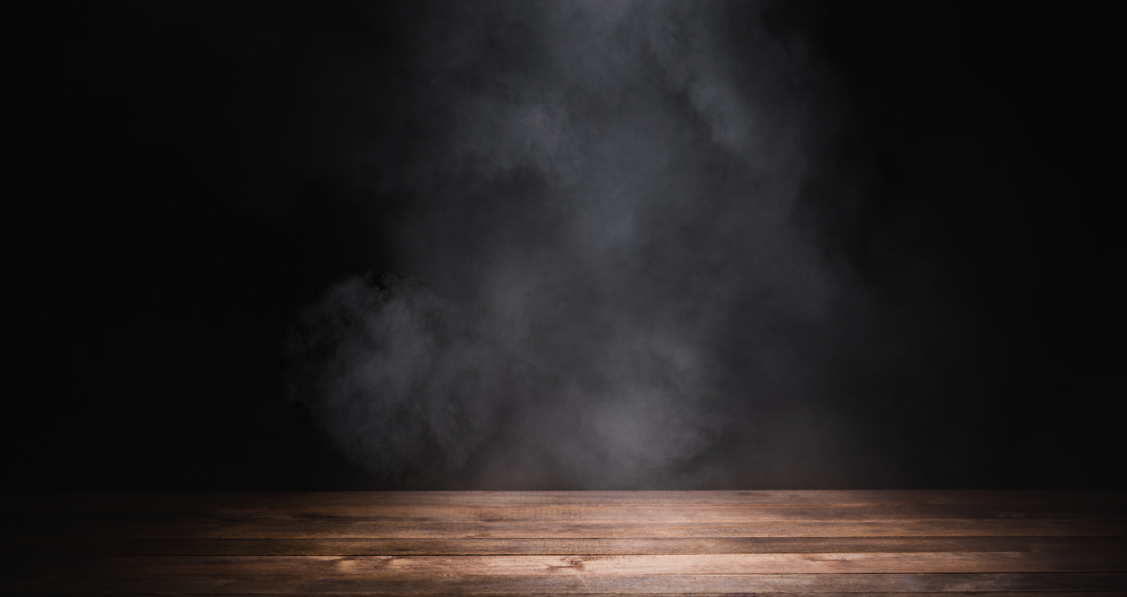Table en bois vide avec de la fumée flottent sur fond sombre